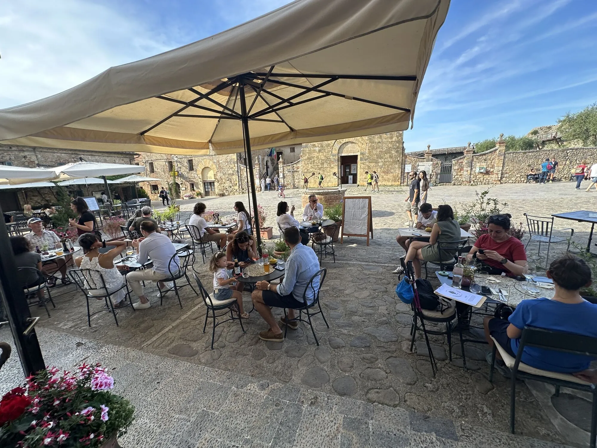 Die Tische des Wine Bistrot auf dem Platz der Burg von Monteriggioni